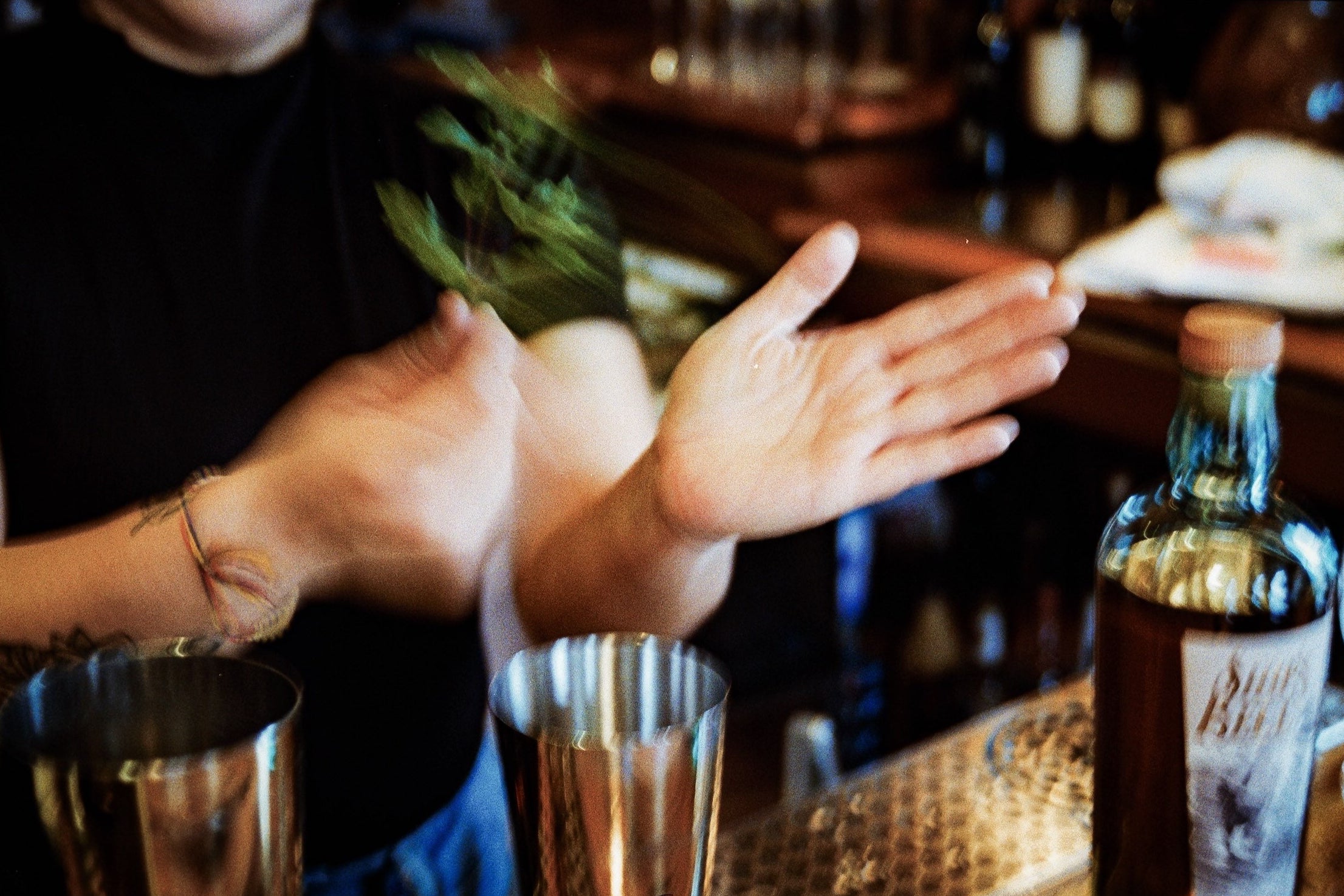 Person making a cocktail with a bottle of Ship's Bell Bourbon in the foreground